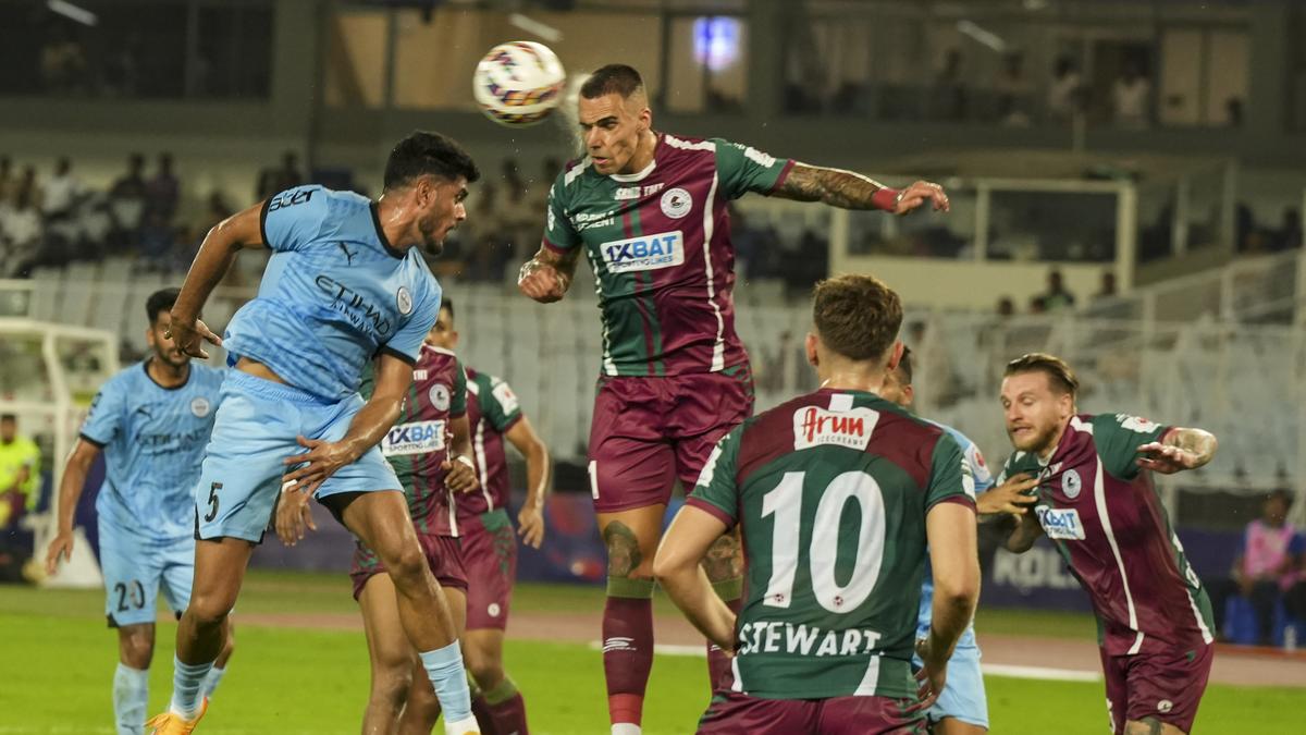 Mohun Bagan Super Giants and Mumbai City FC players vie for the ball during an ISL match, at YBVK Stadium in Kolkata.